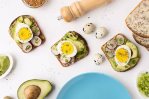 Keto Friendly Recipes: avocado toasts topped with sliced boiled eggs and radish, with quail eggs and a blue plate