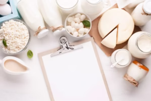 Bariatric Bone Health: milk bottles, cottage cheese, yogurt and a wedge of cheese around a blank clipboard