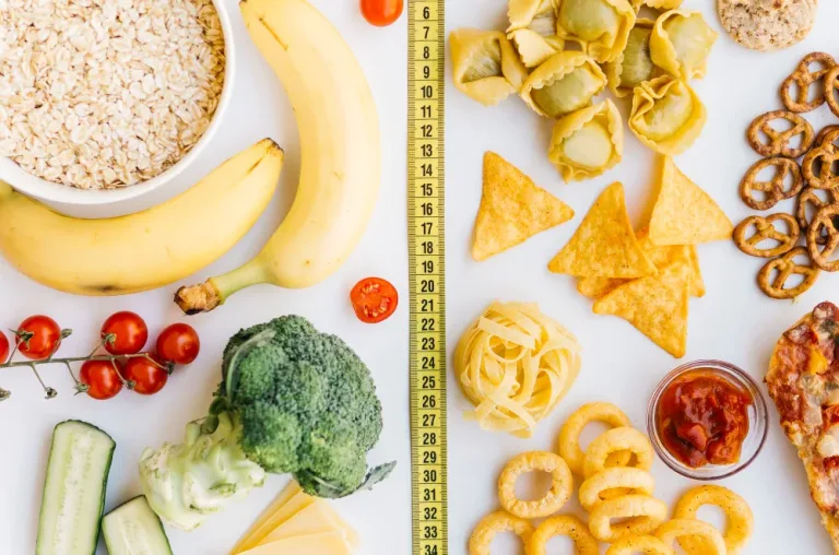 A measuring tape separates oats, bananas and vegetables from chips, pretzels and onion rings